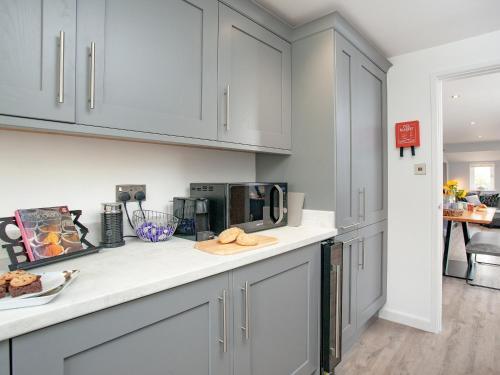 a kitchen with white cabinets and a counter top at 6 Camelside in Wadebridge