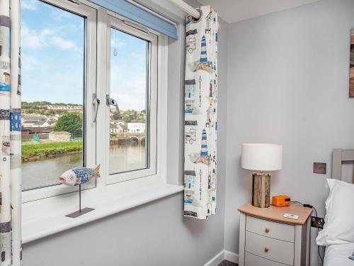 a bedroom with a window with a view of a river at 6 Camelside in Wadebridge