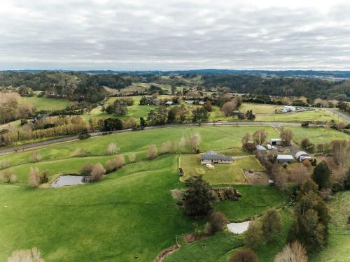an aerial view of a large green field with houses at Kiwi Farm Cabin 2 by Tiny Away in Waitoki