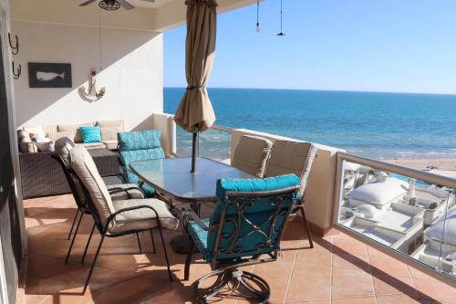 a balcony with a table and chairs and the ocean at Beachfront Condo on Sandy Beach, Las Palmas Resort, 24hrs Security, Free Parking, Free Wi-Fi in Puerto Peñasco