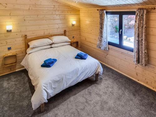 a bedroom with a bed with two blue pillows on it at West End Lodge in Barmston