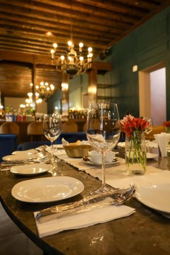 a table with plates and wine glasses on it at Hotel San Francisco Tlaxcala in Tlaxcala de Xicohténcatl