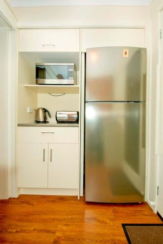 a kitchen with a stainless steel refrigerator and a microwave at Arnie's Place in Yarrawonga