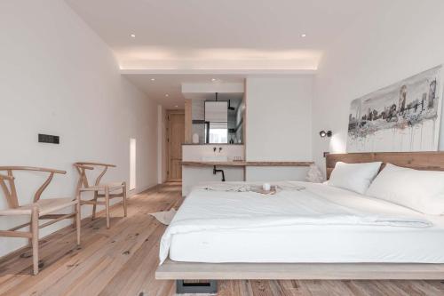 a bedroom with a large white bed and chairs at Boys2men in Chongqing