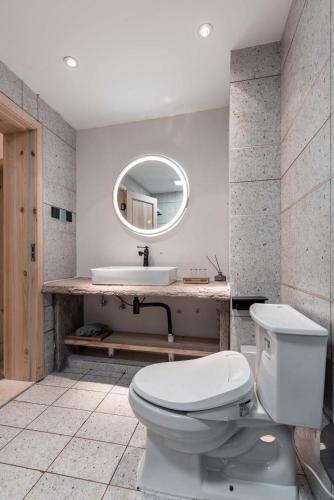 a bathroom with a toilet and a sink and a mirror at Boys2men in Chongqing