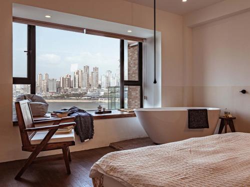 a bathroom with a tub and a bed and a window at Boys2men in Chongqing