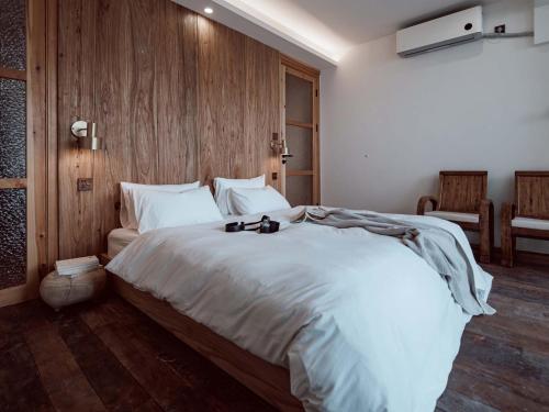 a bedroom with a large white bed with a wooden wall at Boys2men in Chongqing