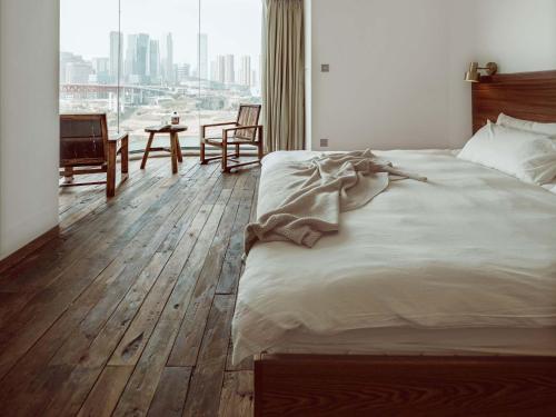 a bedroom with a large bed with a wooden floor at Boys2men in Chongqing