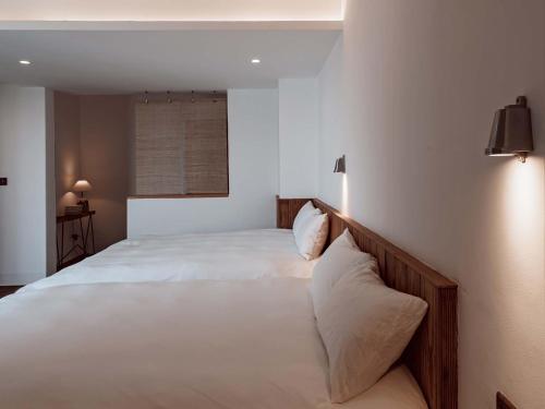 a bedroom with a large white bed with two pillows at Boys2men in Chongqing