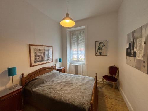 a bedroom with a bed and a chair and a window at Maison 4 chambres, 2 étoiles, près plage, port de pêche – Les Sables-d'Olonne - FR-1-197-605 in Les Sables-dʼOlonne