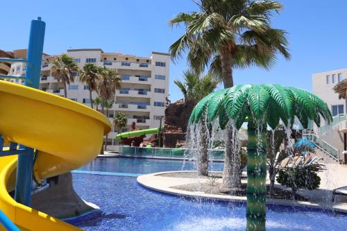a water park with a slide and a palm tree at Beachfront Condo on Sandy Beach, Las Palmas Resort, 24hrs Security, Free Parking, Free Wi-Fi in Puerto Peñasco