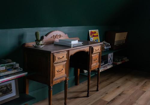 an old wooden desk in a room with a green wall at The Eyrie, your private Ocean View apartment in Head of Jeddore