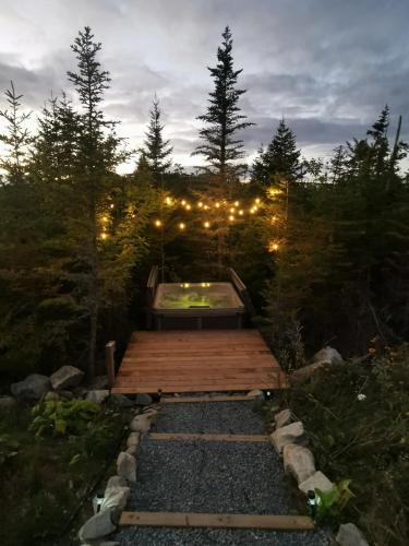 a wooden deck with a pool in the middle of a forest at The Eyrie, your private Ocean View apartment in Head of Jeddore
