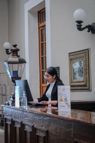 a woman sitting at a counter with a laptop at Hotel San Francisco Tlaxcala in Tlaxcala de Xicohténcatl