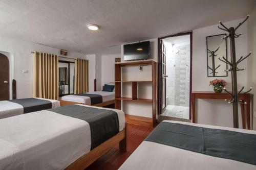 クスコにあるInkagardenhotelsのベッド2台とテレビがあるホテルの部屋