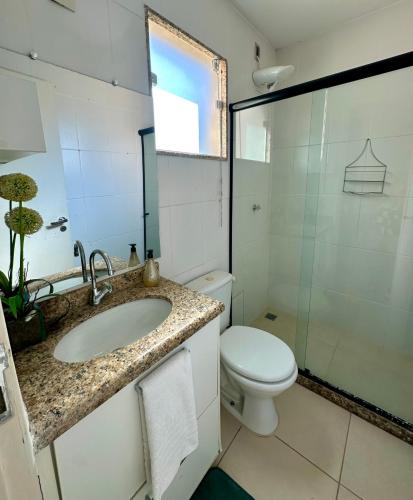 a bathroom with a toilet and a sink and a shower at Costazul Confort Flats in Rio das Ostras