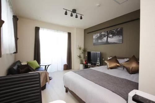 a bedroom with a bed and a chair and a window at Frieden Haus in Tokyo
