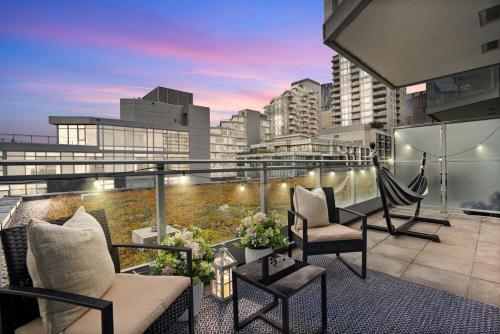 a balcony with couches and chairs on a building at Luxury Waterfront Suite with City Views and AC in Calgary