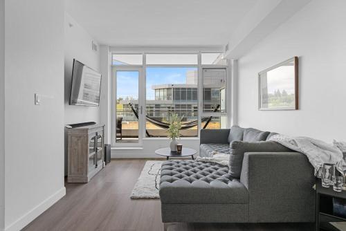 a living room with a couch and a large window at Luxury Waterfront Suite with City Views and AC in Calgary