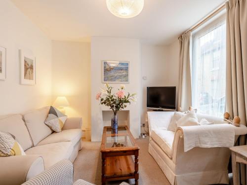 ein Wohnzimmer mit Sofa und Tisch in der Unterkunft Wellspring Cottage in Whitstable