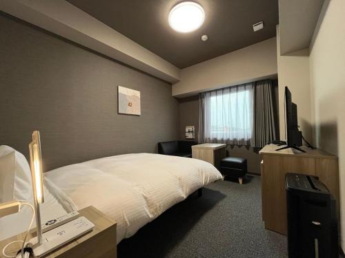 a hotel room with a bed and a television at Hotel Route Inn Higashi Matsue in Matsue