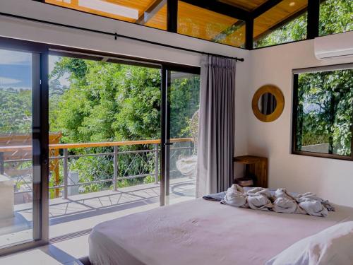 a bedroom with a bed and a large window at Villa Hermanos Luxury Home with Ocean View in Sámara