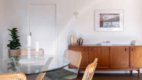 a dining room with a glass table and chairs at Clippers 1 - Pet Friendly Holiday Home - Holiday Yamba in Yamba