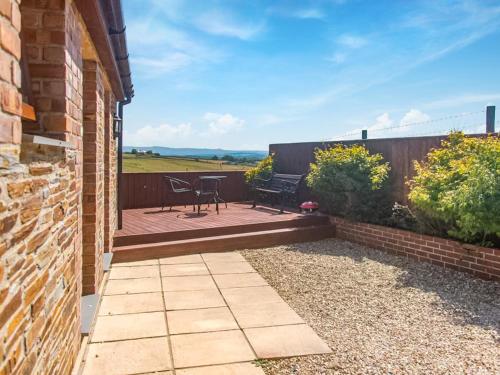a patio with a table and chairs on a brick building at The Retreat - Uk48331 in Lifton