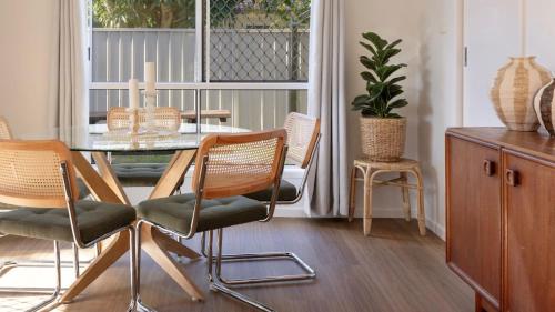 a dining room with a glass table and chairs at Clippers 1 - Pet Friendly Holiday Home - Holiday Yamba in Yamba