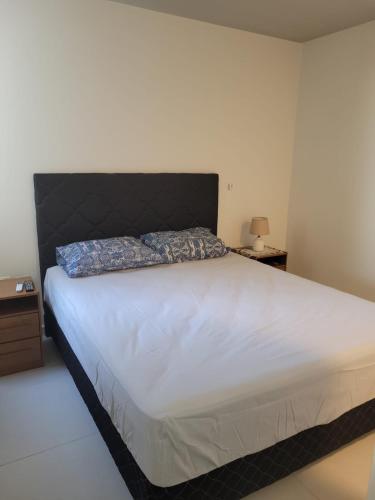 a bedroom with a large white bed with a black headboard at insignia5 in Luque
