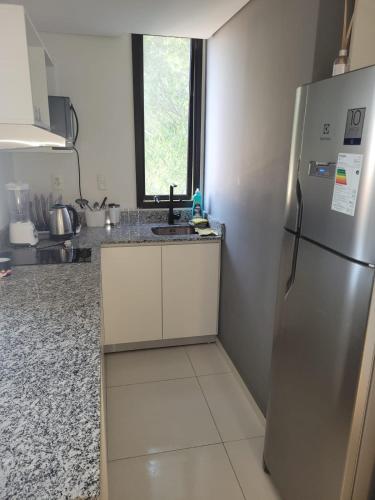 a kitchen with a stainless steel refrigerator and a window at insignia5 in Luque