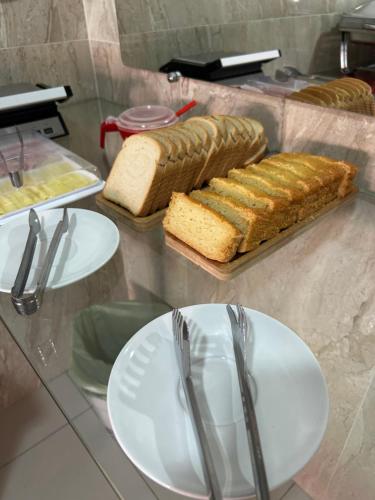 a table with plates and forks and bread on it at Pousada Oliveira in Remanso