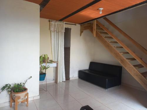 a living room with a couch and a staircase at Cabaña Noche De Luna in Jardin