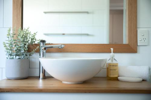 a white bowl sink on a wooden counter in a bathroom at Trailside in Bright in Bright
