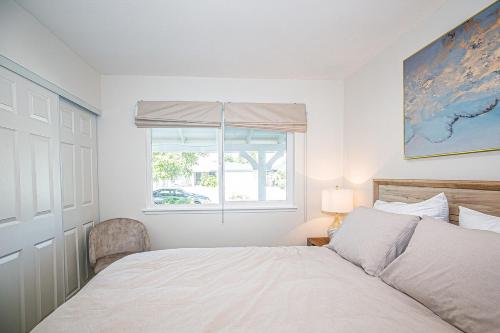 a white bedroom with a bed and a window at Fun 3BR with Pool & Slide, Pet Friendly in San Jose in San Jose