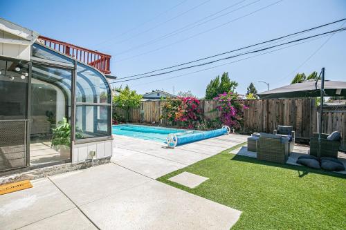 a backyard with a swimming pool and a house at Fun 3BR with Pool & Slide, Pet Friendly in San Jose in San Jose