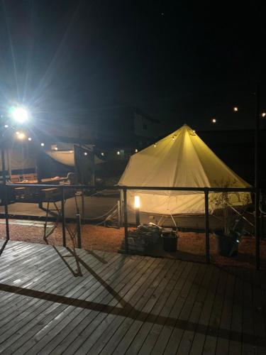 a white tent on a deck at night at KAMADOBA glamping in Tōganemachi