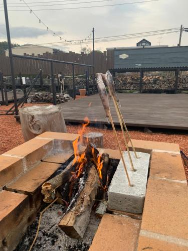 a fire pit with a stick in it with flames at KAMADOBA glamping in Tōganemachi