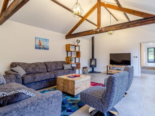a living room with a couch and a table at Skylark Barn-Uk31354 in Swaffham