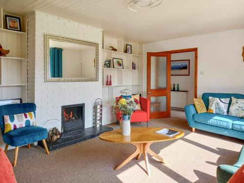 a living room with a couch and a fireplace at Beech House in Torcastle