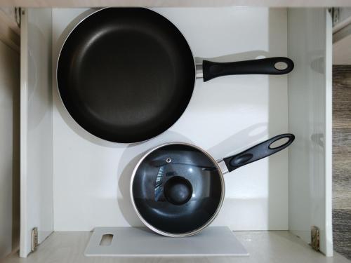 a frying pan and a pan on top of a toilet at Colonial On Gladstone Motel in Gisborne