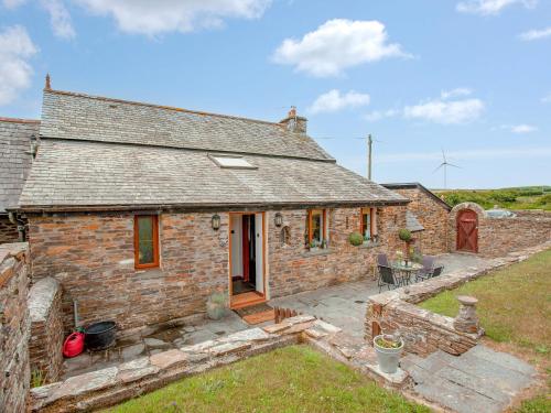 een afbeelding van een stenen huisje met een terras bij Railway Cottage in Camelford
