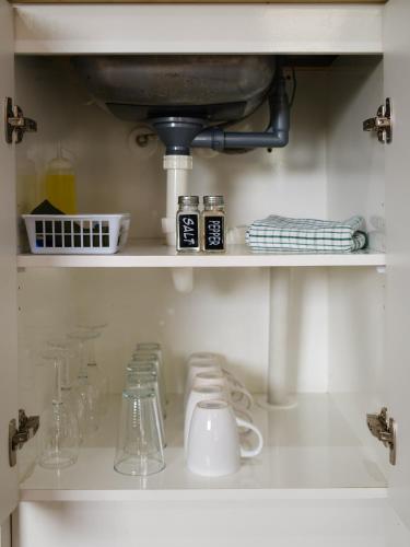 a kitchen counter with a sink and some glasses at Colonial On Gladstone Motel in Gisborne