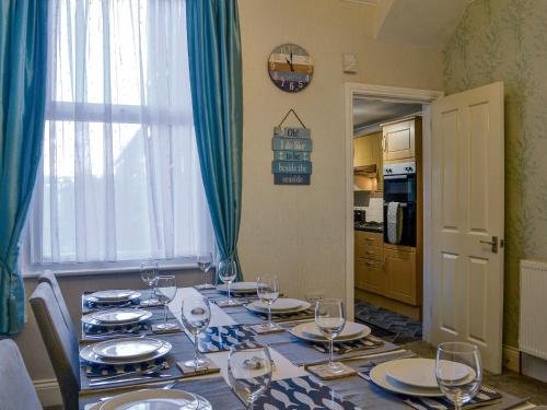 a dining room table with glasses and plates on it at Zack's Seaside Stay in Bridlington