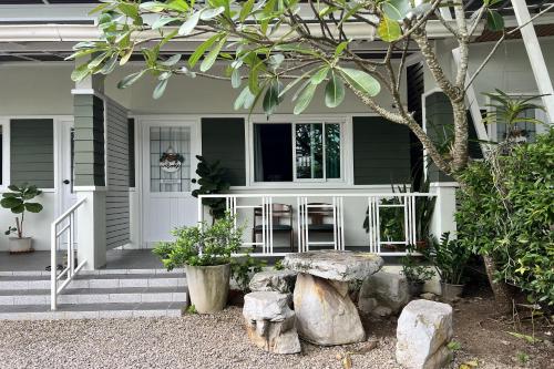 a house with a bench on the front porch at Bann Kam B&B in Krabi town