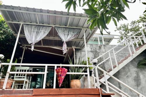 a balcony of a house with a red umbrella at Bann Kam B&B in Krabi town
