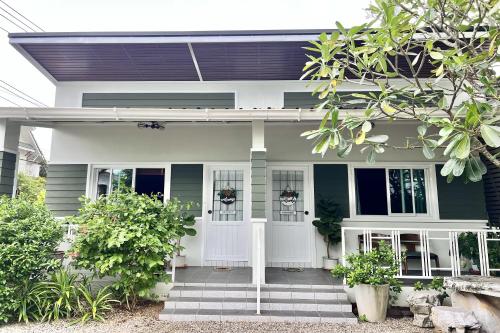 a green house with a white front door at Bann Kam B&B in Krabi town
