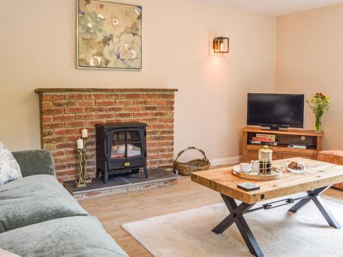 a living room with a fireplace and a tv at Mutton Hill Cottage in Pembroke