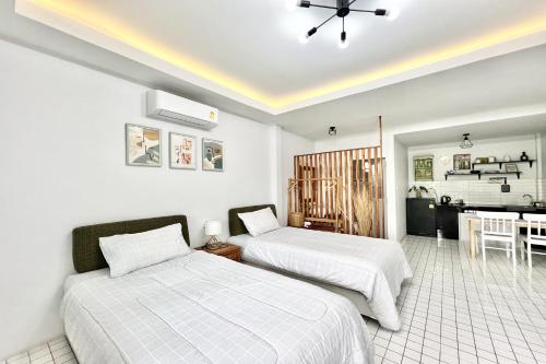a bedroom with two beds and a dining room at Bann Kam B&B in Krabi town