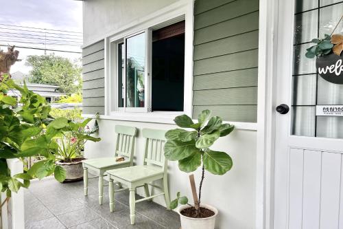 a porch with two chairs and a window at Bann Kam B&B in Krabi town
